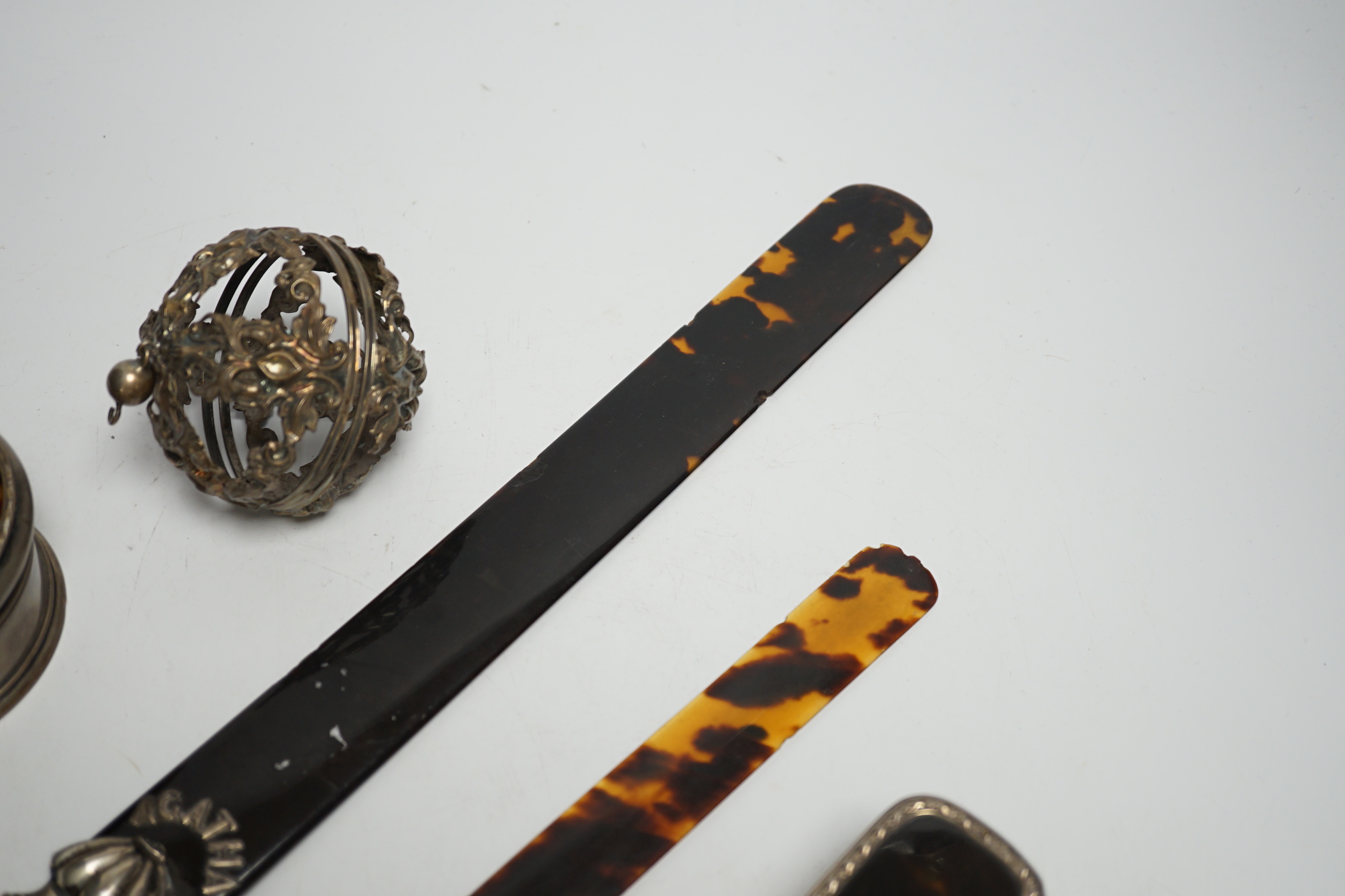 A late Victorian silver handled tortoiseshell page turner, a small page turner, a silver and tortoiseshell box and brush and a white metal pomander case.